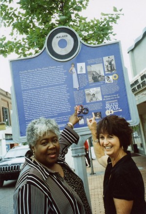 Dorothy Moore shows Central MS Blues Society member, Peggy Brown, her early points of career interests on the Blues Trail Marker unveiled at the Alamo Theater, Jackson, MS, May 22, 2008.